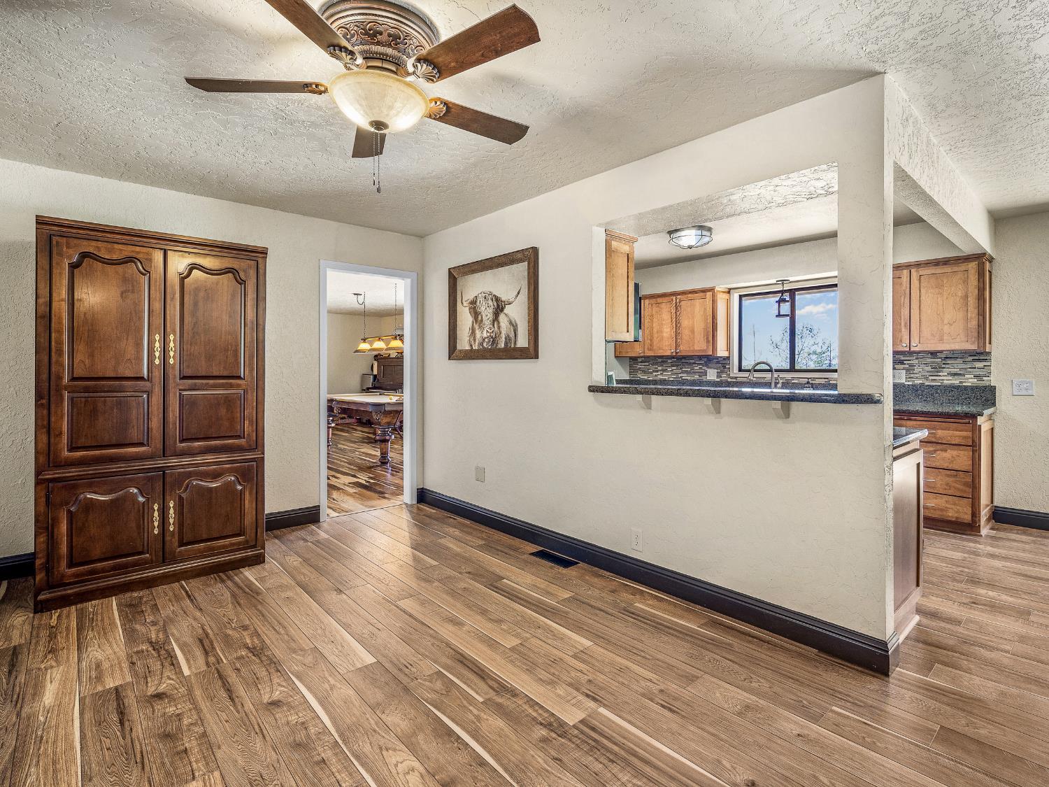 17065 Niles Road Jackson, CA 95642 - Photo 17 of 26 a view of a kitchen with wooden floor and a ceiling fan