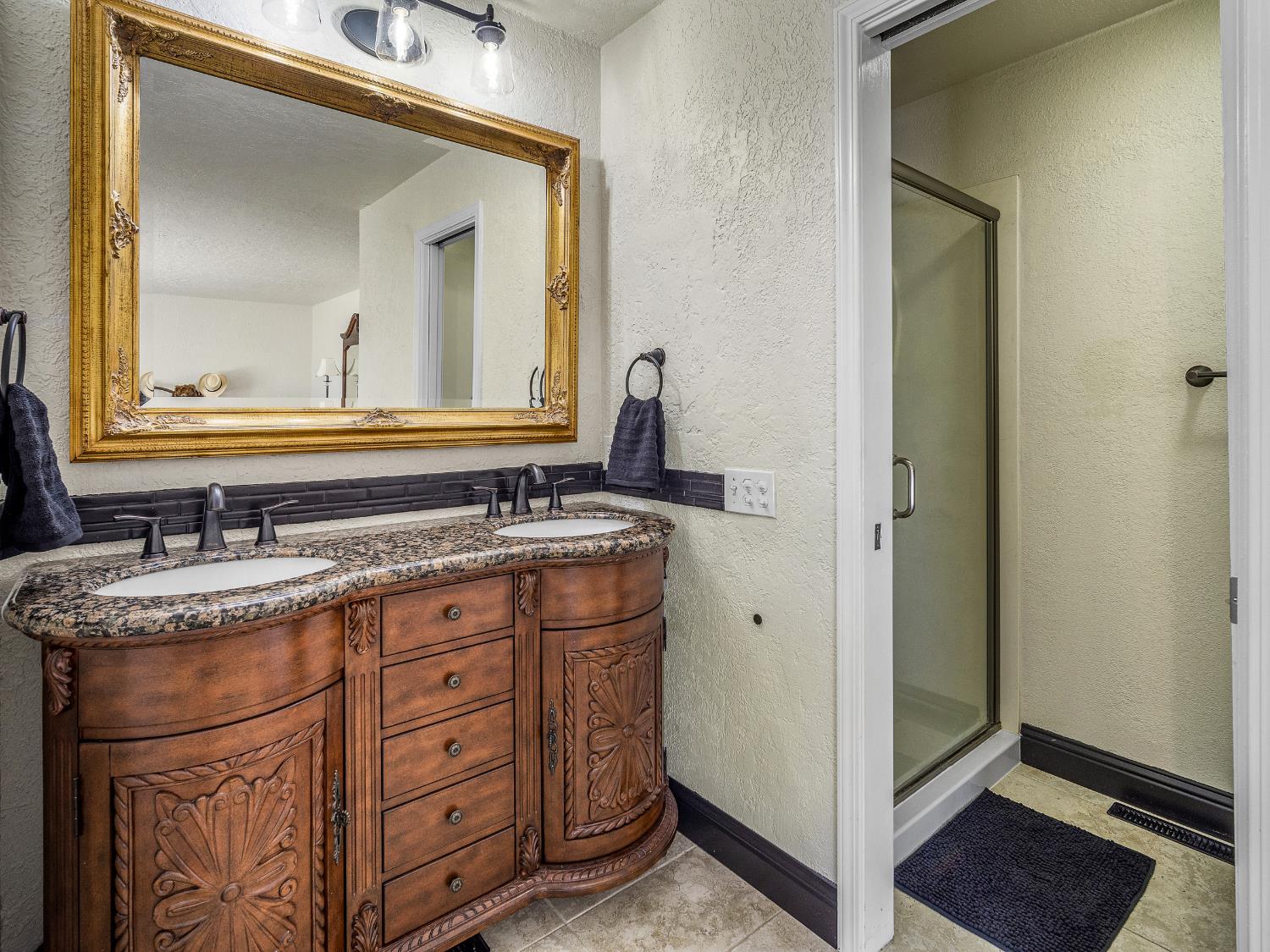 17065 Niles Road Jackson, CA 95642 - Photo 22 of 26 a bathroom with a granite countertop sink vanity and mirror