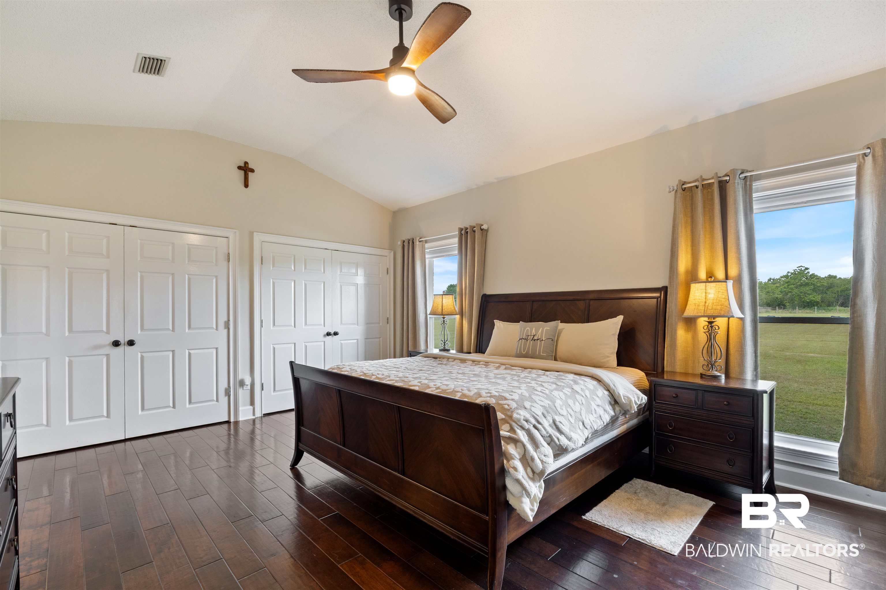 9855 Stucki Road Elberta, AL 36530 - Photo 29 of 54 Bedroom featuring two closets, vaulted ceiling, dark wood-style flooring, and ceiling fan