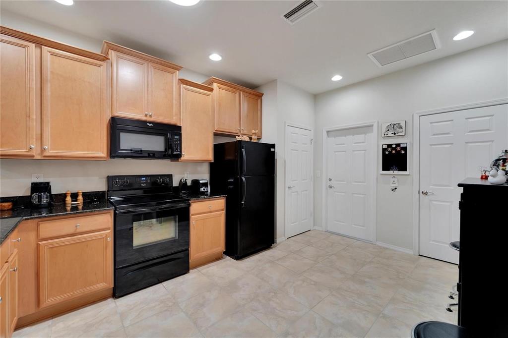 428 Seneca Falls Drive Apollo Beach, FL 33572 - Photo 4 of 31 a kitchen with stainless steel appliances granite countertop a refrigerator stove and microwave