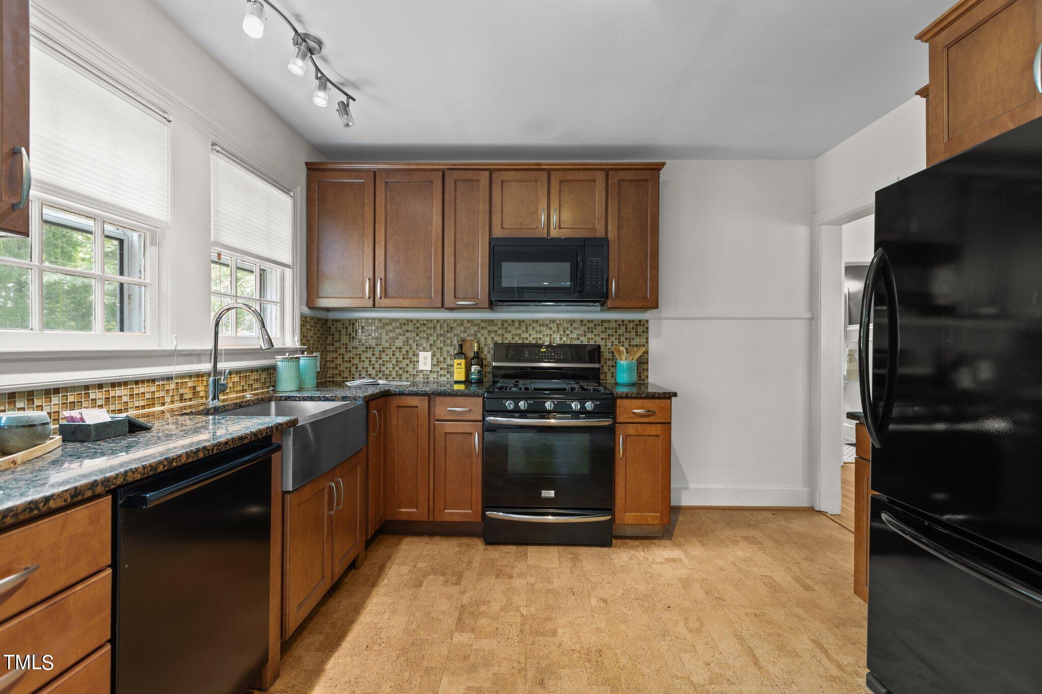 1702 James Street Durham, NC 27707 - Photo 19 of 40 a kitchen with stainless steel appliances granite countertop a stove a sink and a refrigerator