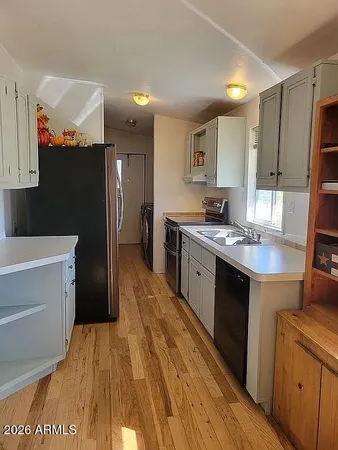 a room with a sink cabinets and a wooden floor