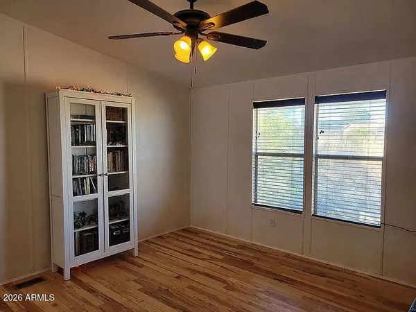 a view of an empty room with kitchen and closet area