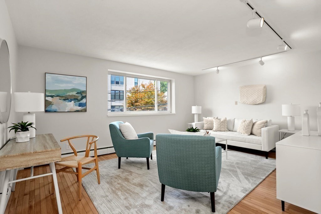 410 Langley Road, Unit 5 Newton, MA 02459 - Photo 3 of 23 a living room with furniture and a wooden floor
