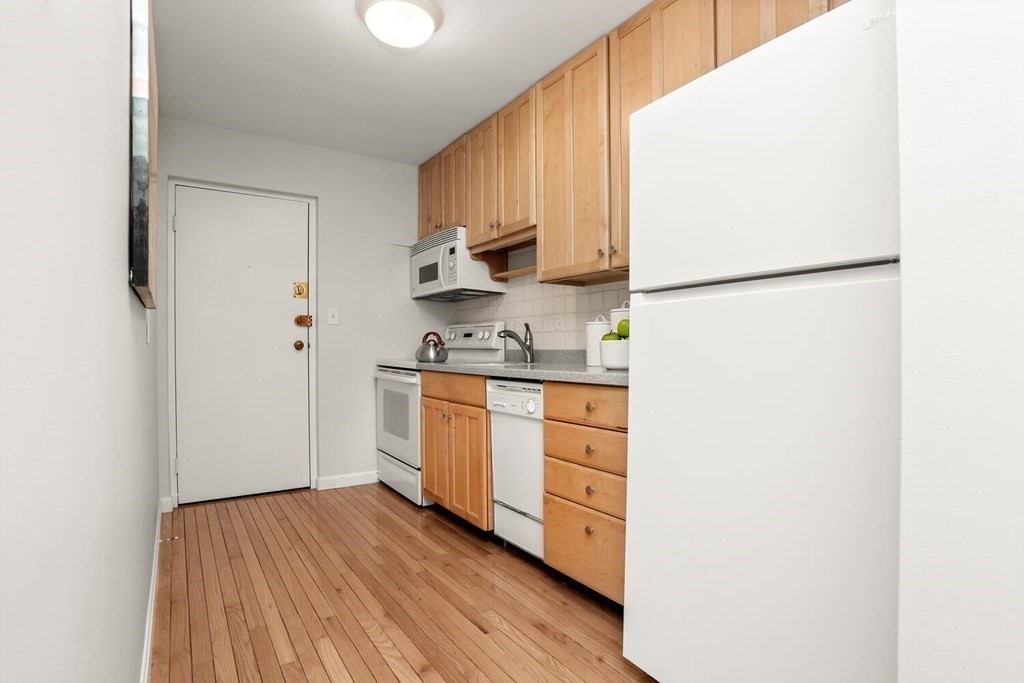 410 Langley Road, Unit 5 Newton, MA 02459 - Photo 8 of 23 a kitchen with stainless steel appliances a refrigerator sink and cabinets