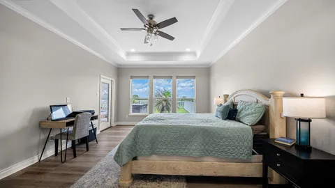 a bedroom with a bed a chandelier and mirror