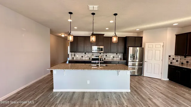 a kitchen with a sink a stove and a microwave