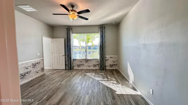a view of a room with wooden floor and a window