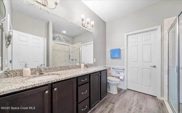 a bathroom with a granite countertop sink toilet and shower