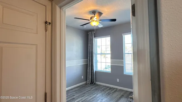 a view of workspace with wooden floor and ceiling fan
