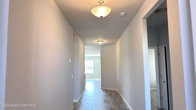 a view of a hallway with wooden floor