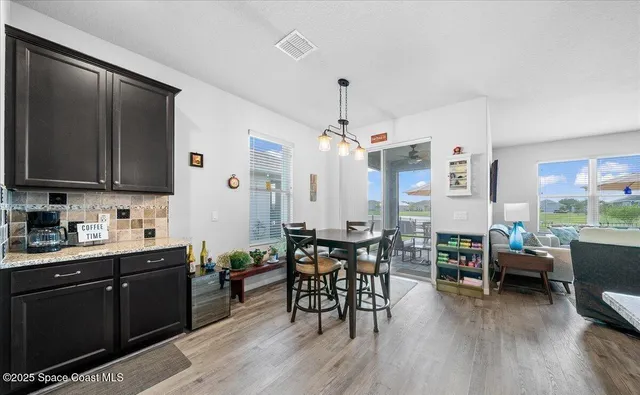 a kitchen with stainless steel appliances kitchen island granite countertop a stove a refrigerator a sink and a wooden floor