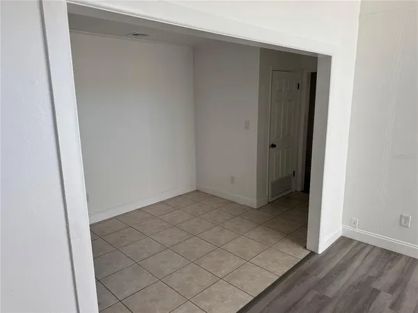 a view of an empty room with a window and a ceiling fan