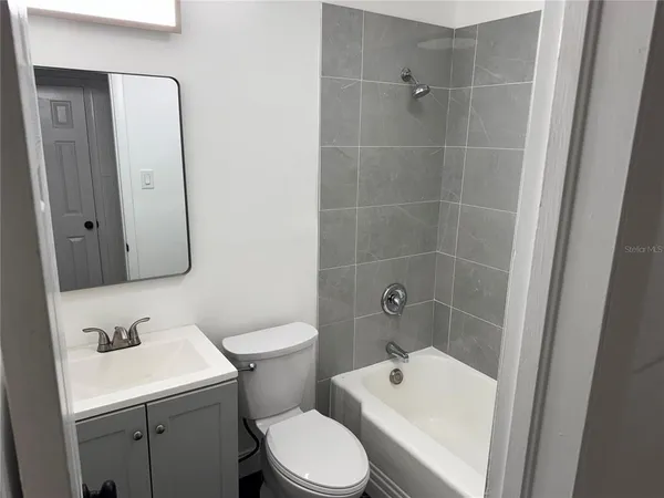 a kitchen with a refrigerator a stove top oven and cabinets