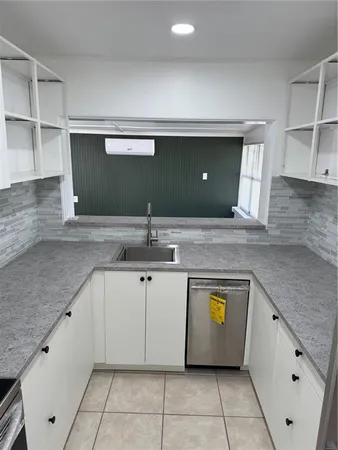 a kitchen with granite countertop a stove sink and cabinets
