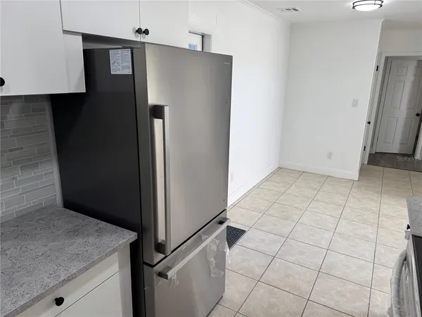 a kitchen with a refrigerator sink and cabinets