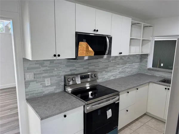a view of kitchen island with furniture and refrigerator