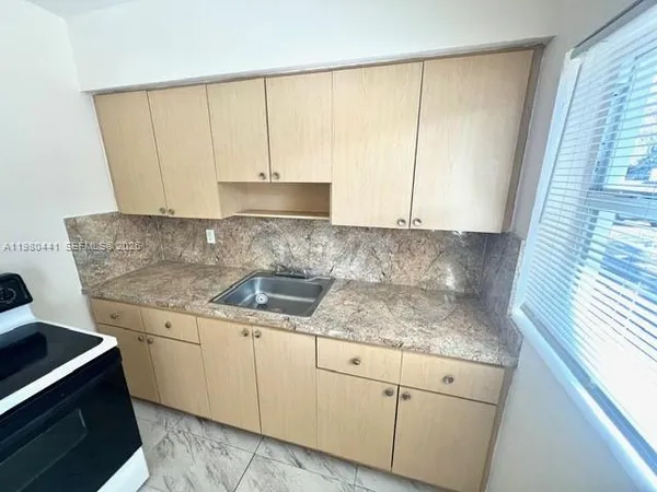 a kitchen with granite countertop white cabinets and white appliances