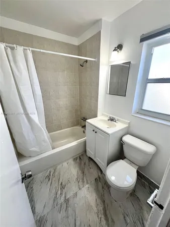 a bathroom with a white toilet a sink and a bathtub