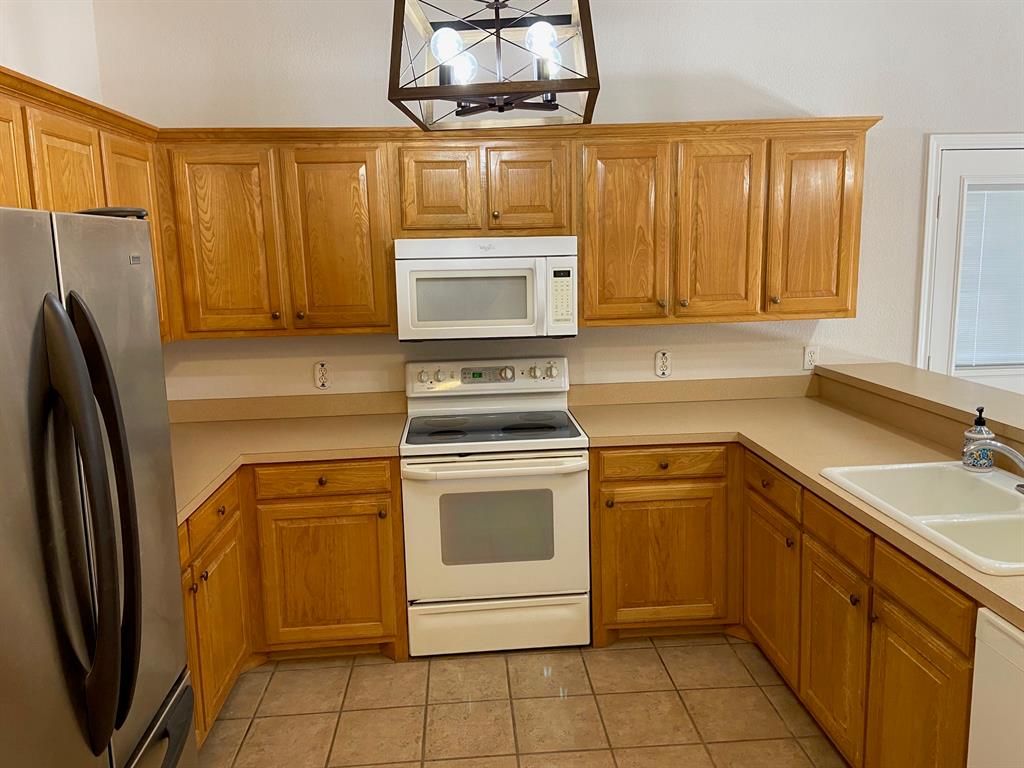 27101 Meadowmore Court Whitney, TX 76692 - Photo 7 of 32 Kitchen with view of the fridge, microwave, stove.