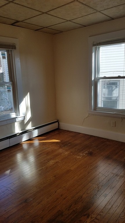 69 East Central Street Worcester, MA 01605 - Photo 6 of 12 an empty room with wooden floor and windows