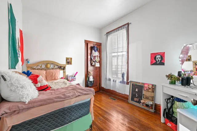 a bedroom with a bed and a wooden floor