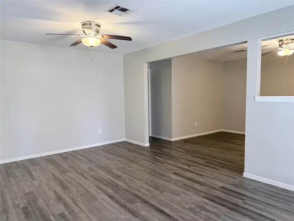 a view of an empty room with wooden floor