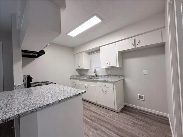 a kitchen with granite countertop a sink and cabinets