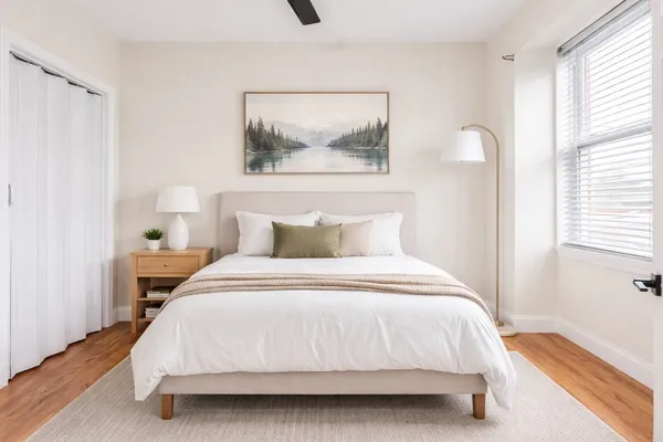 a bedroom with a bed and a painting on the wall