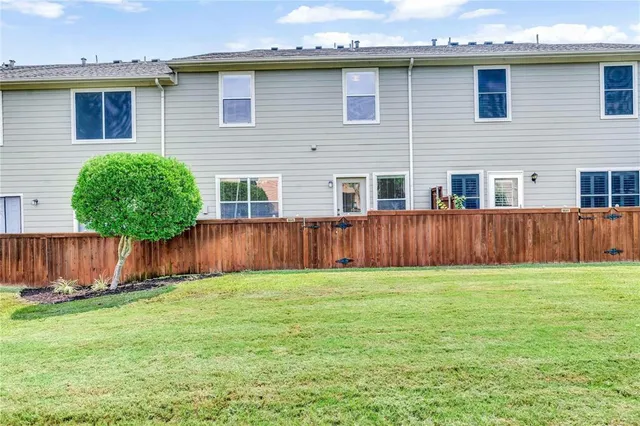 a view of a house with a yard and wooden fence