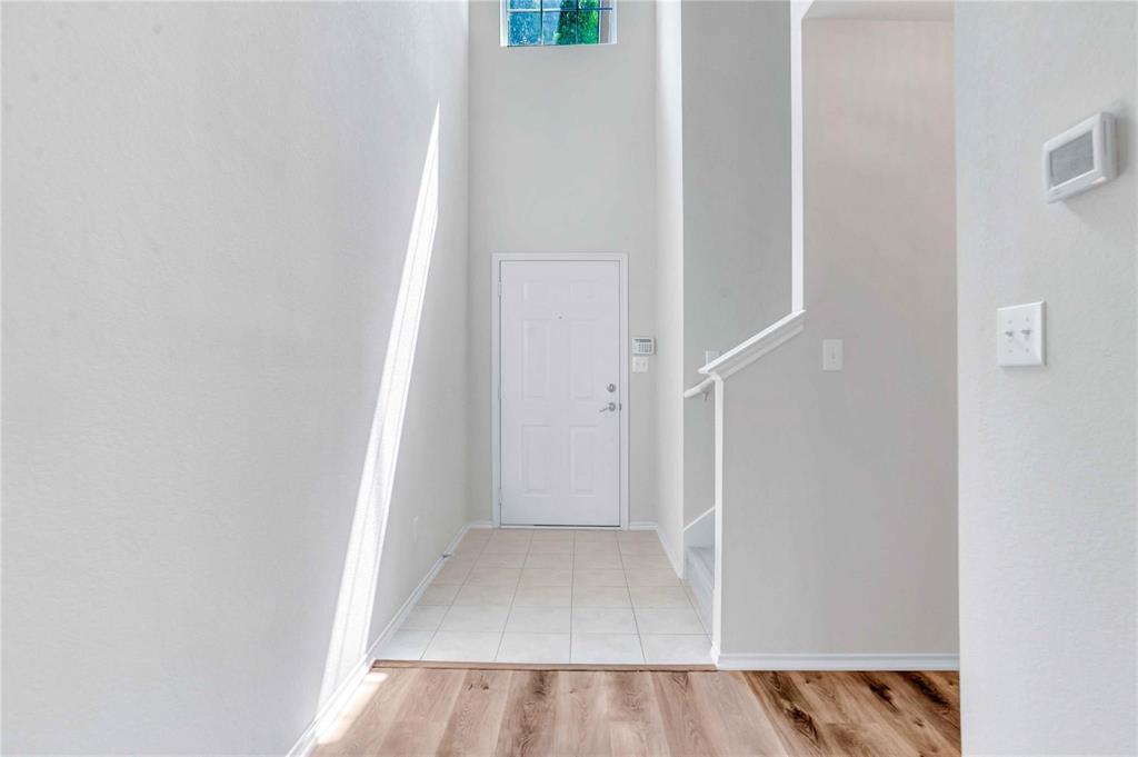 9845 Rockwall Road Plano, TX 75025 - Photo 3 of 14 a view of a hallway with wooden floor and entryway