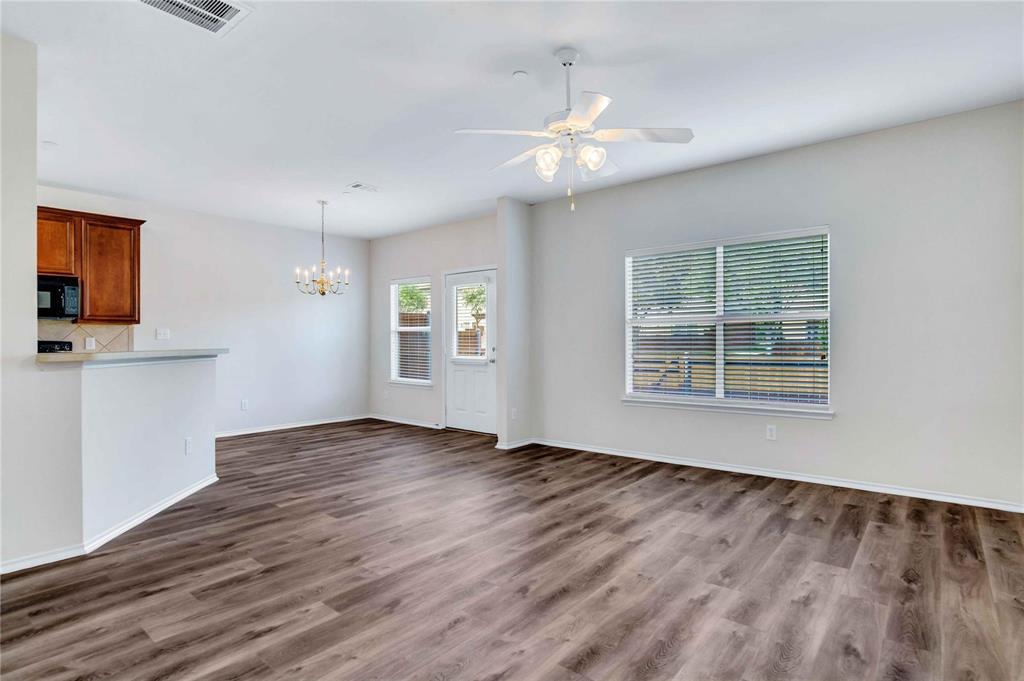 9845 Rockwall Road Plano, TX 75025 - Photo 4 of 14 a view of an empty room with wooden floor and a window