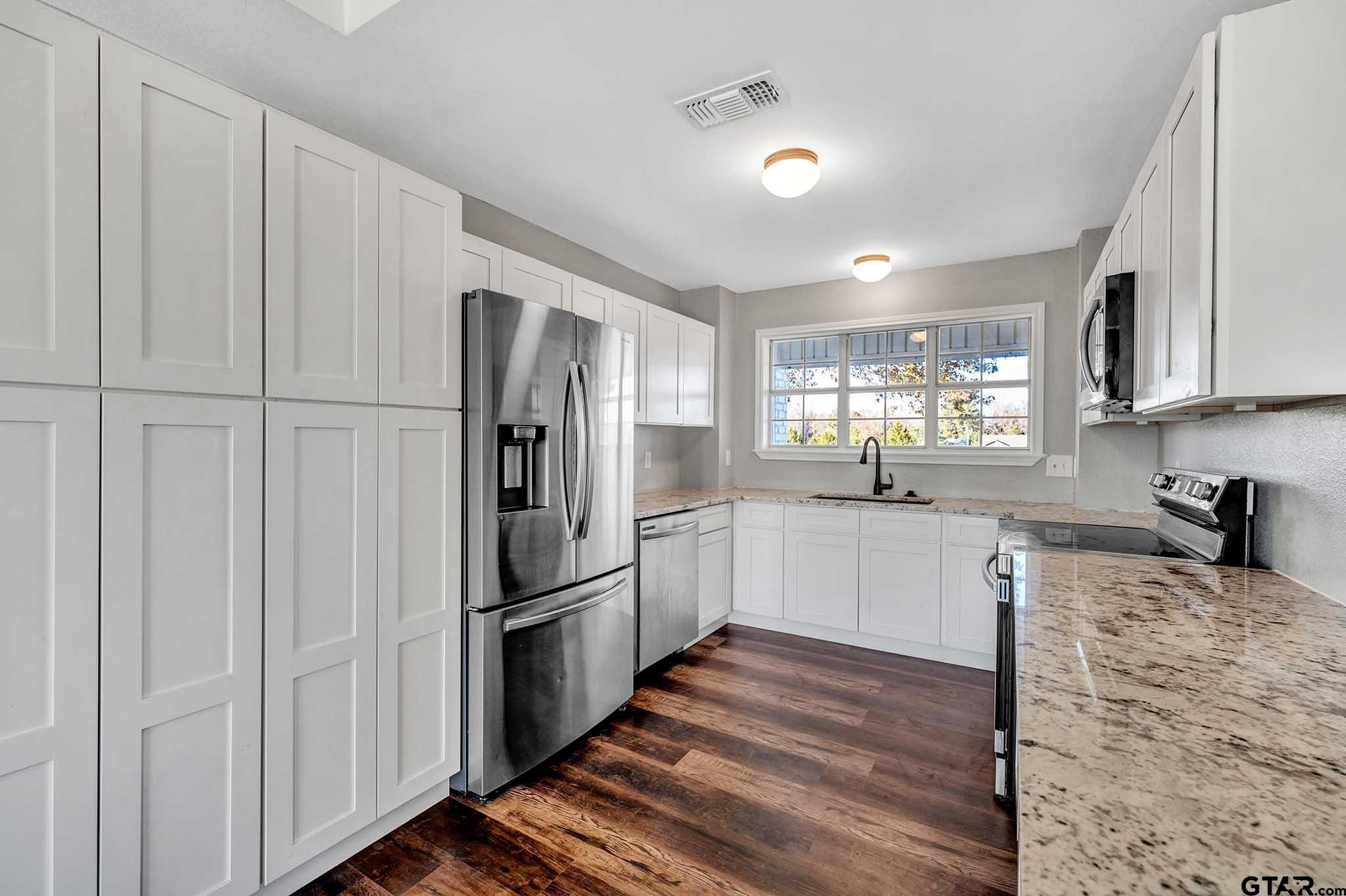 11670 Cr 345 Winona Tx 75792 Winona, TX 75792 - Photo 8 of 39 a kitchen with granite countertop white cabinets and stainless steel appliances