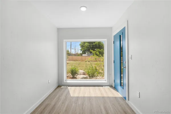 an empty room with wooden floor and a window