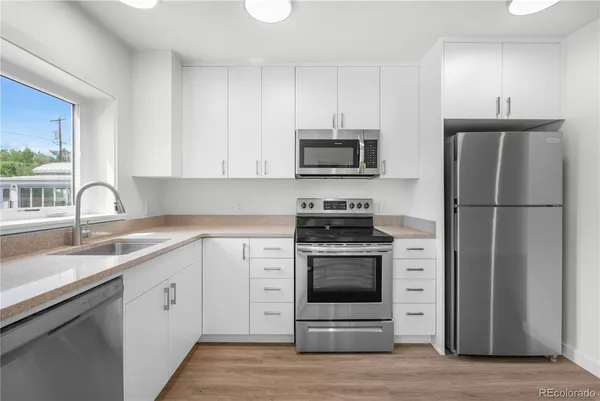 a kitchen with cabinets stainless steel appliances and a sink