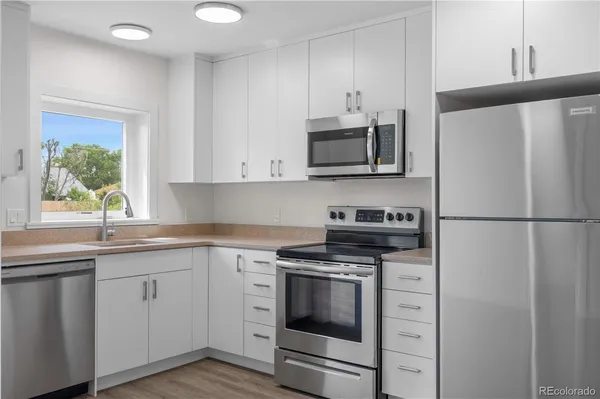 a kitchen with cabinets stainless steel appliances and a window