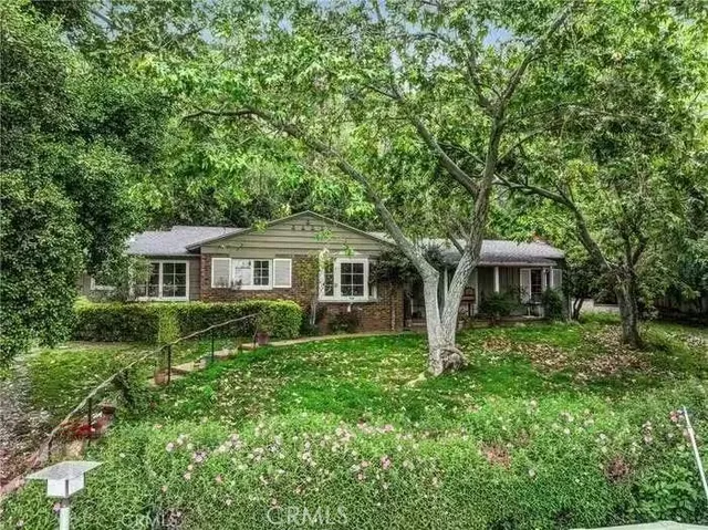 a front view of a house with yard and green space