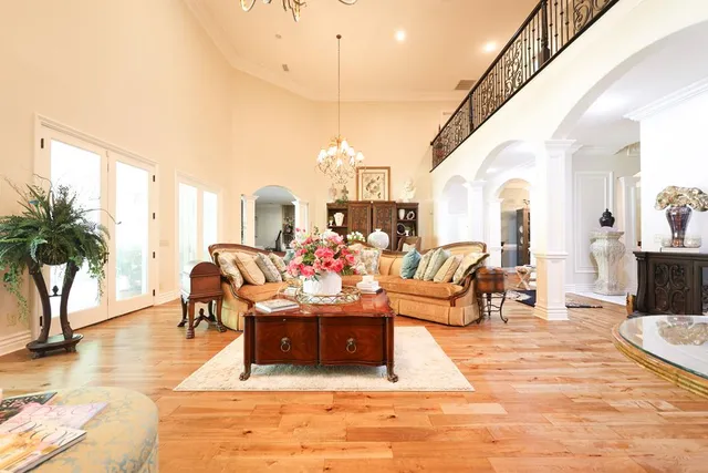 a living room with furniture kitchen view and a chandelier