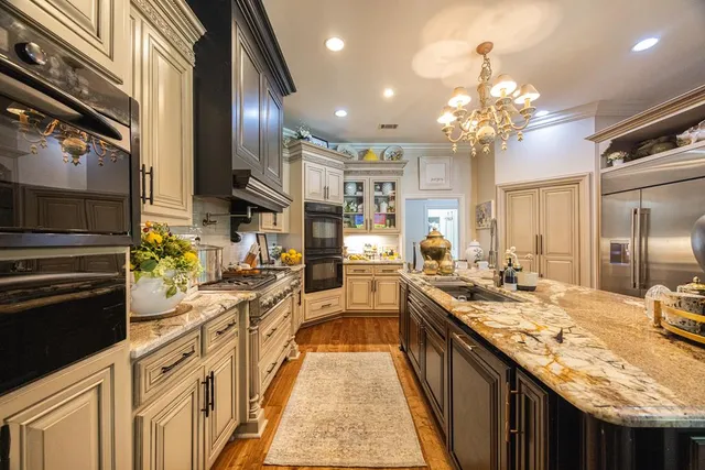 a spacious bedroom with a bed a chandelier and a couch