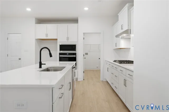 a kitchen with stainless steel appliances granite countertop a sink stove and cabinets