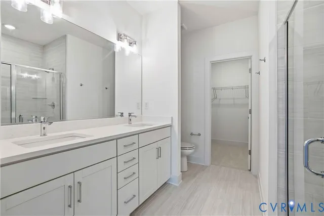 a bathroom with a double vanity sink toilet and shower