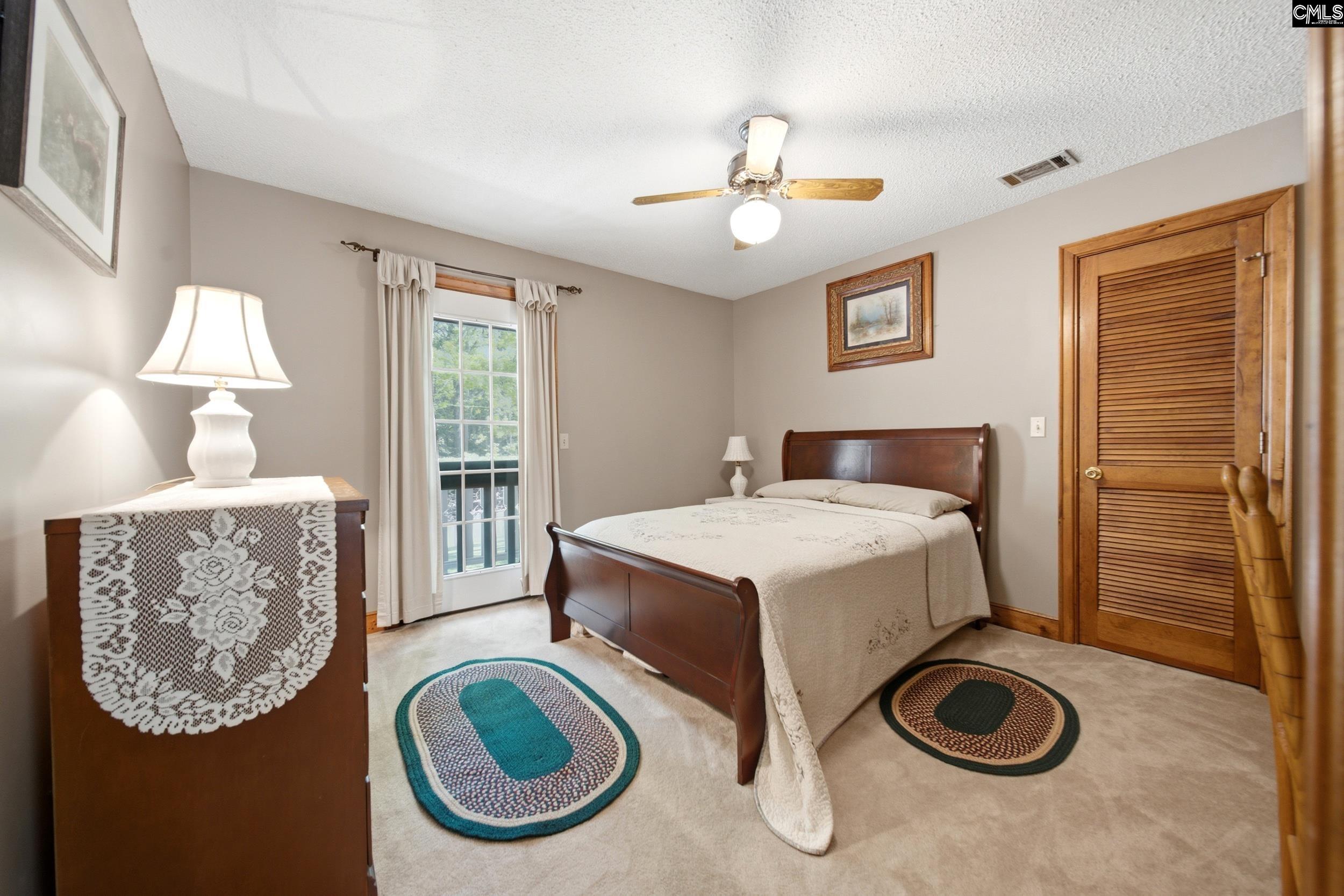 4324 Syrup Mill Road Ridgeway, SC 29130 - Photo 25 of 61 a bedroom with a bed and a chandelier