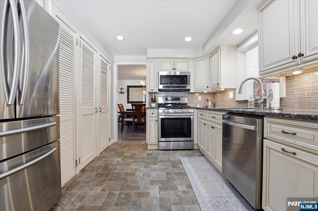 72 West Saddle River Road Waldwick, NJ 07463 - Photo 15 of 50 a kitchen with stainless steel appliances granite countertop a stove top oven a sink and a refrigerator with wooden floor