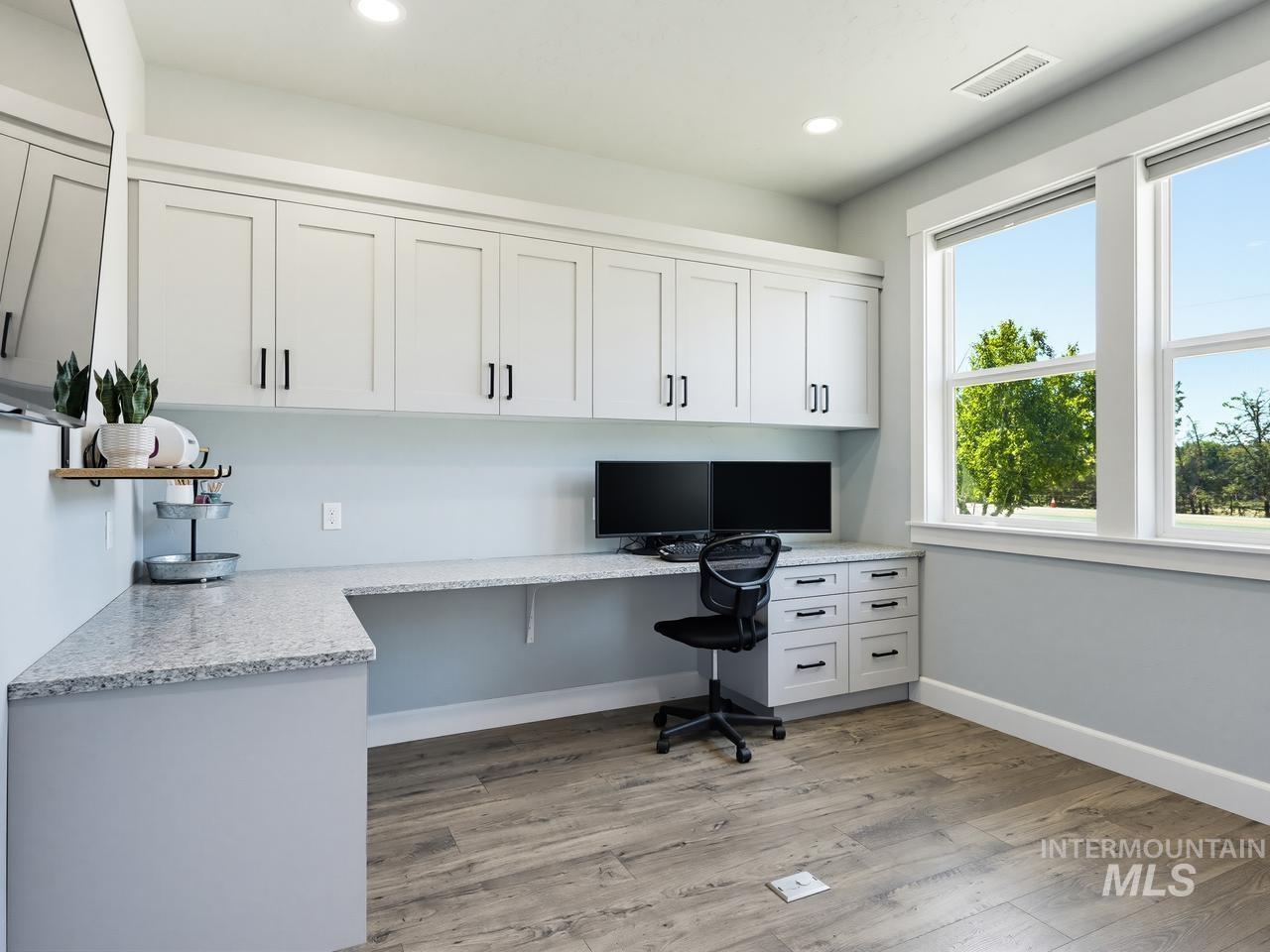 4950 West Columbia Road Nampa, ID 83687 - Photo 27 of 50 Dedicated office space featuring extensive built-in cabinetry, wrap-around countertop, dual windows, recessed lighting, and wood-finish flooring
