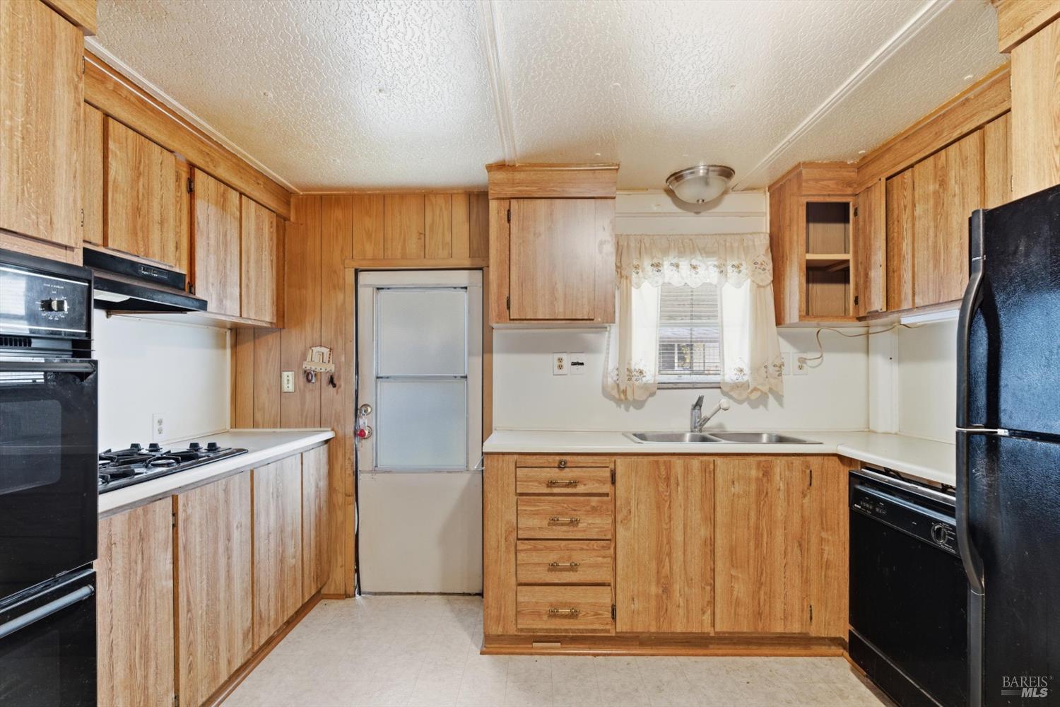 305 Aileen Avenue Santa Rosa, CA 95407 - Photo 8 of 15 a kitchen with a refrigerator a stove and cabinets