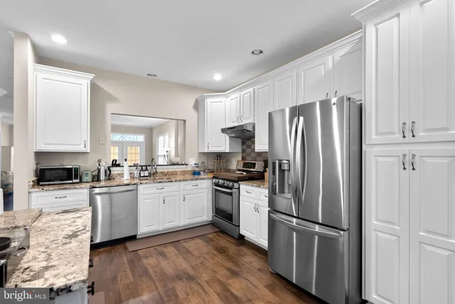 a kitchen with a refrigerator a stove top oven and kitchen island