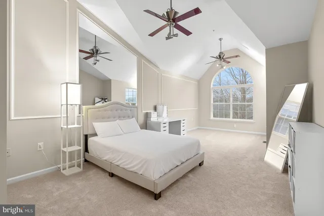 a bedroom with a bed lamp and a large window