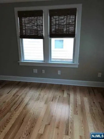 a view of a room with wooden floor and windows