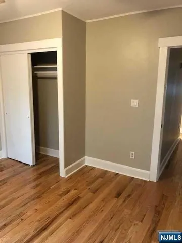 an empty room with wooden floor and closet