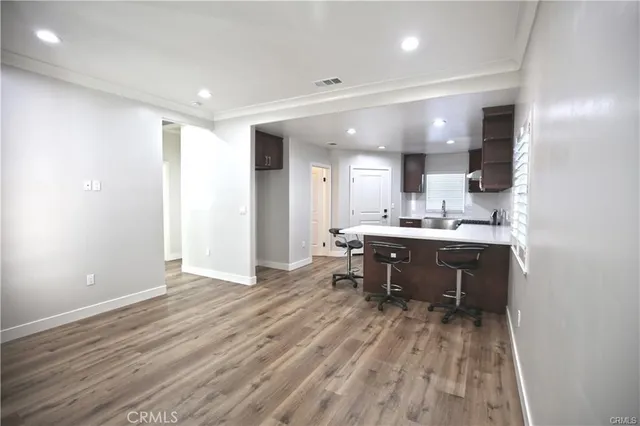 a open kitchen with kitchen island a sink dishwasher a stove and a refrigerator with wooden floor